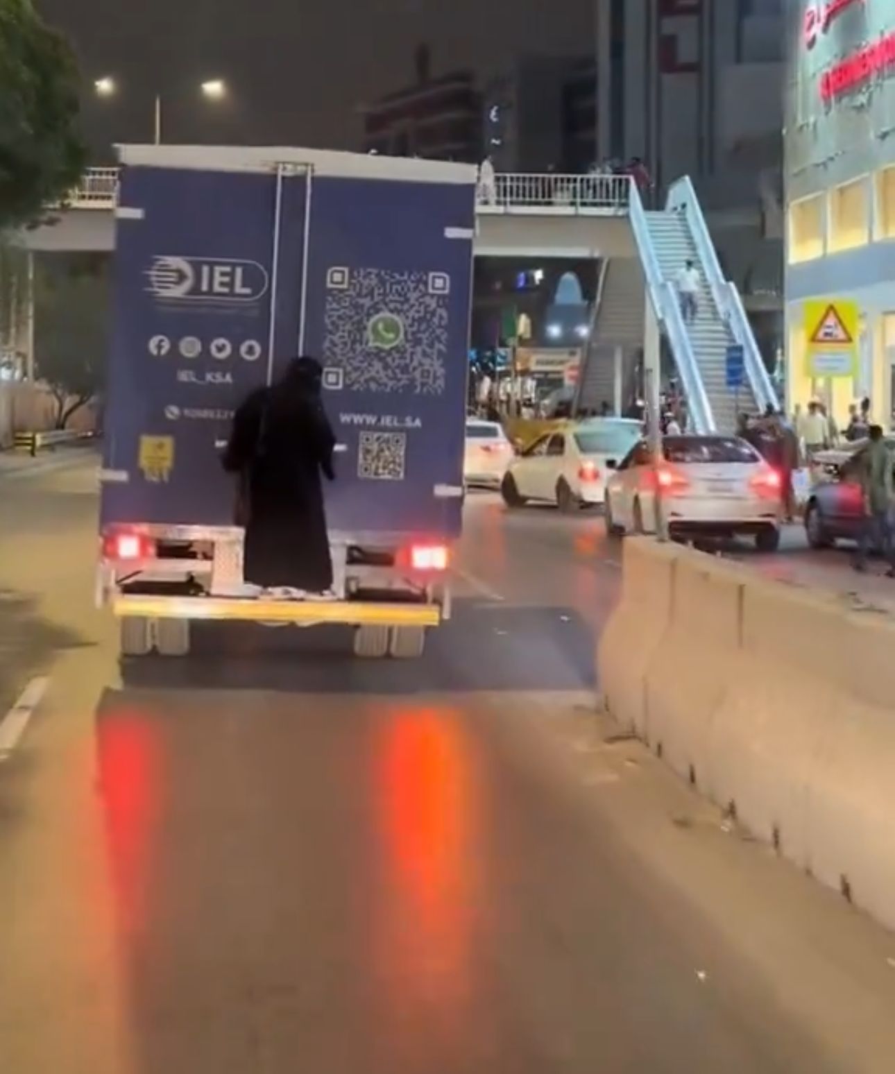 امرأة تتشبث بحافلة تسير على الطريق في بطحاء الرياض .. فيديو