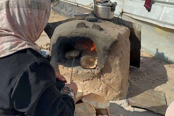 نازحة فلسطينية تصنع الخبز على فرن الطين القديم لإطعام أسرتها ومساعدة النازحين نازحة فلسطينية تصنع الخبز على فرن الطين القديم لإطعام أسرتها ومساعدة النازحين - الخليج 365 عربي