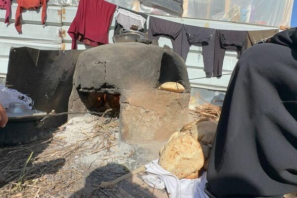 نازحة فلسطينية تصنع الخبز على فرن الطين القديم لإطعام أسرتها ومساعدة النازحين نازحة فلسطينية تصنع الخبز على فرن الطين القديم لإطعام أسرتها ومساعدة النازحين - الخليج 365 عربي
