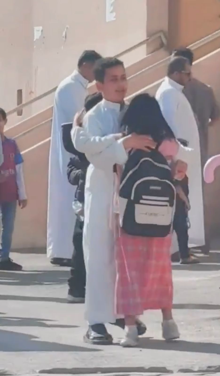 شاب صغير ينتظر أخته أمام إحدى المدارس بالأحضان .. فيديو