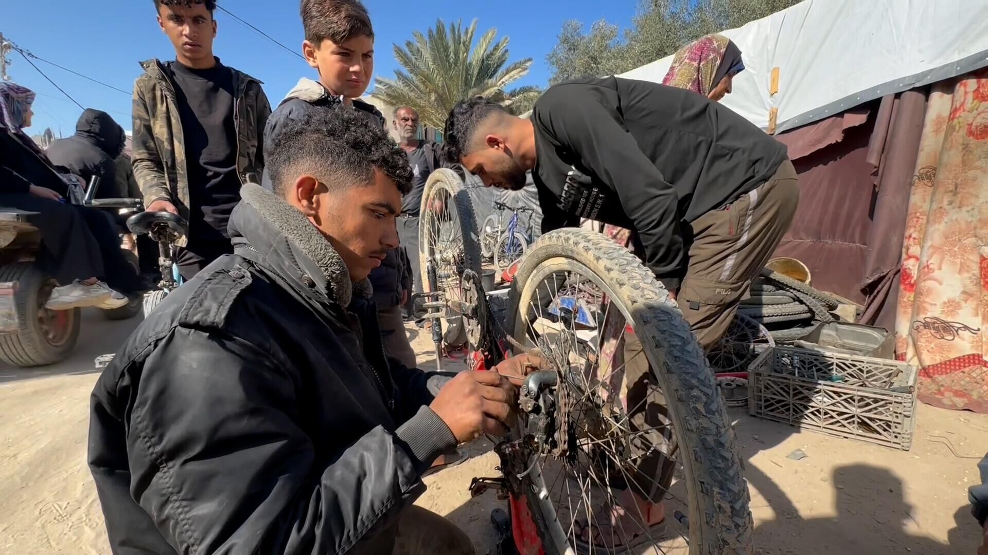 عائلة نازحة تحول خيمتها إلى مكان لتصليح الدرجات الهوائية في دير البلح وسط قطاع غزة... صور وفيديو