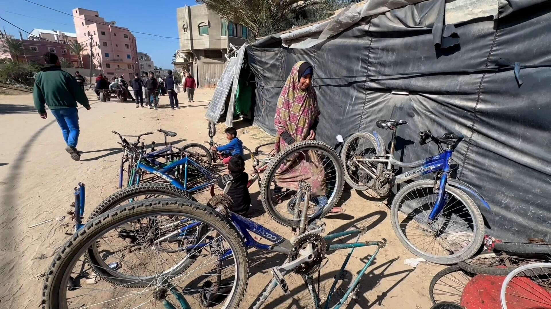 عائلة نازحة تحول خيمتها إلى مكان لتصليح الدرجات الهوائية في دير البلح وسط قطاع غزة... صور وفيديو