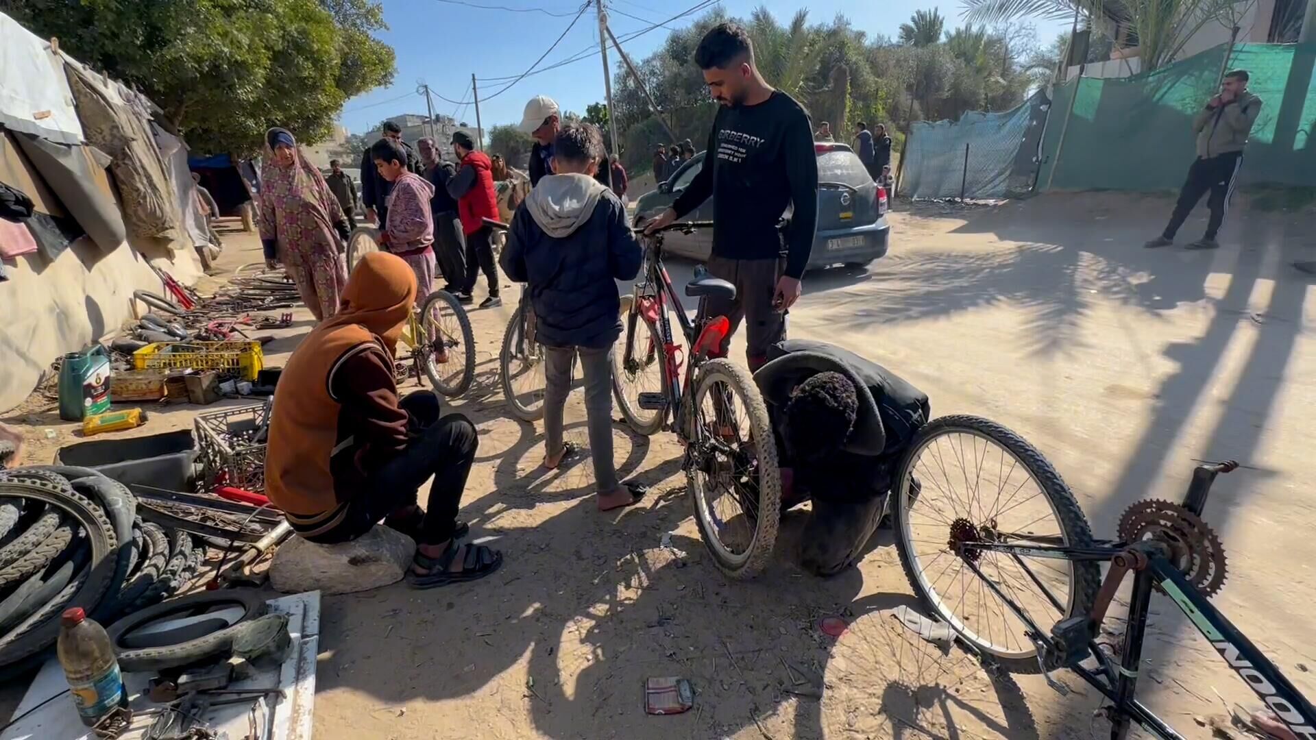 عائلة نازحة تحول خيمتها إلى مكان لتصليح الدرجات الهوائية في دير البلح وسط قطاع غزة... صور وفيديو