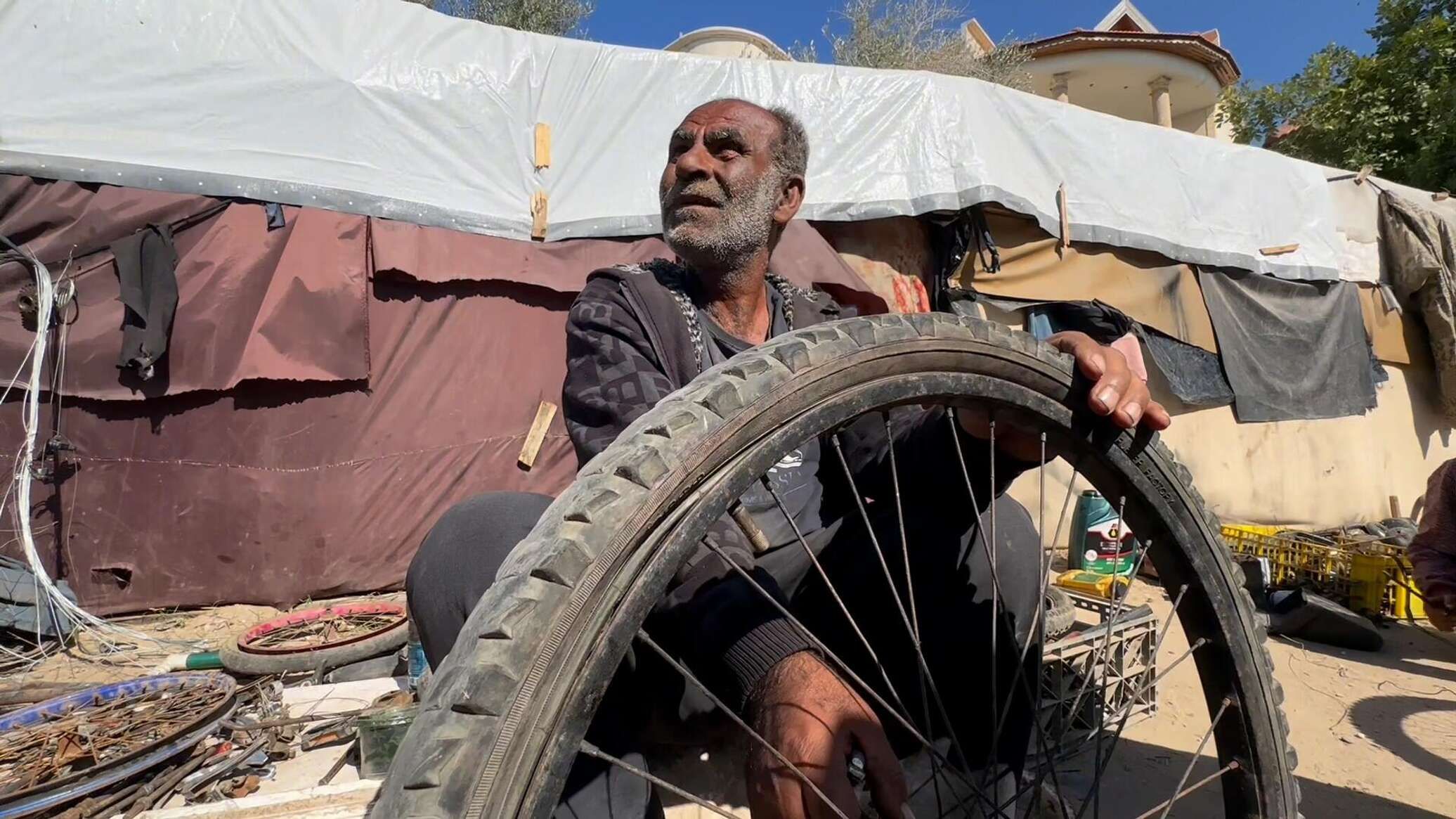 عائلة نازحة تحول خيمتها إلى مكان لتصليح الدرجات الهوائية في دير البلح وسط قطاع غزة... صور وفيديو