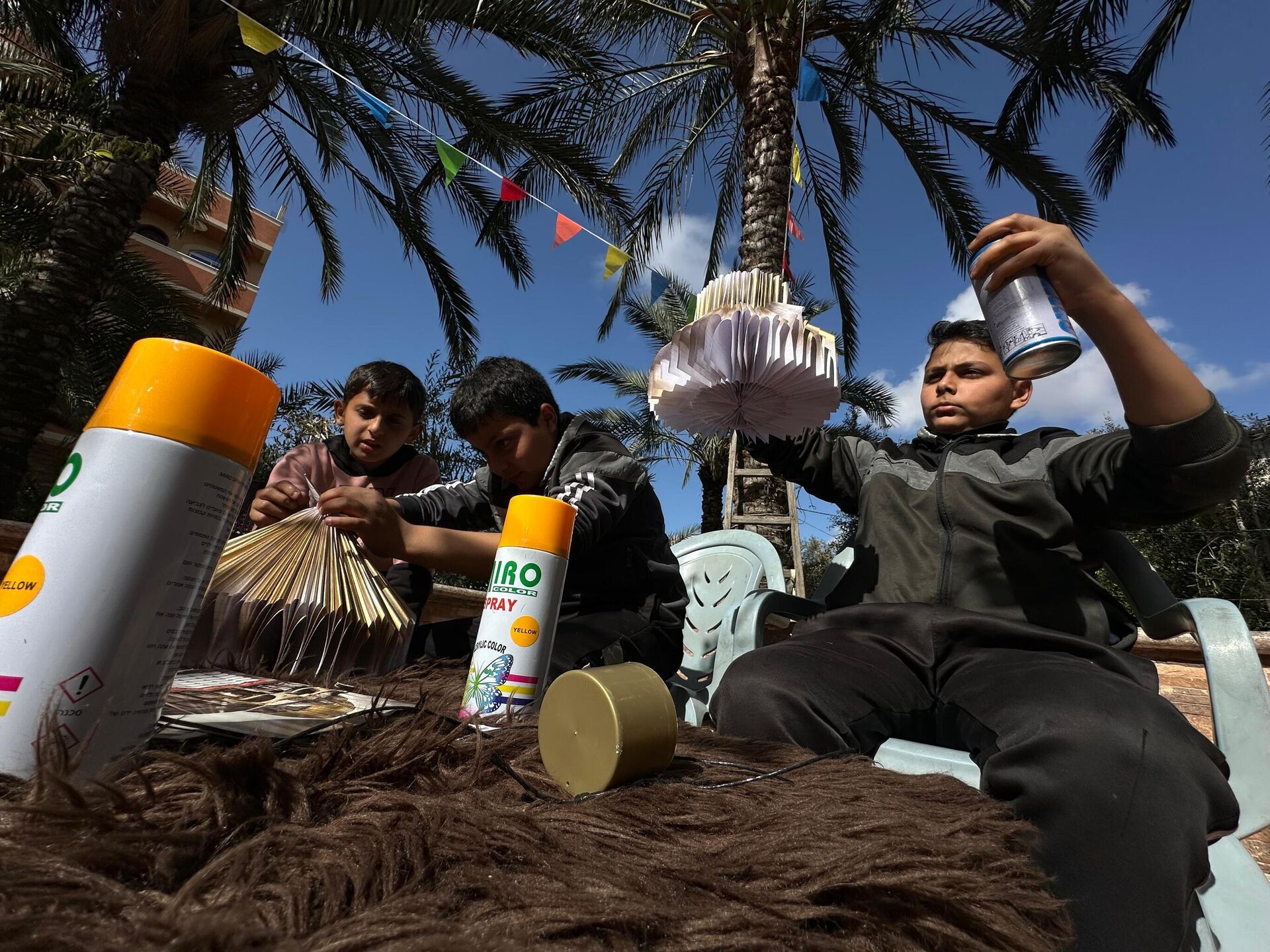 أطفال غزة يصنعون فوانيس رمضان من بقايا كتبهم المدرسية