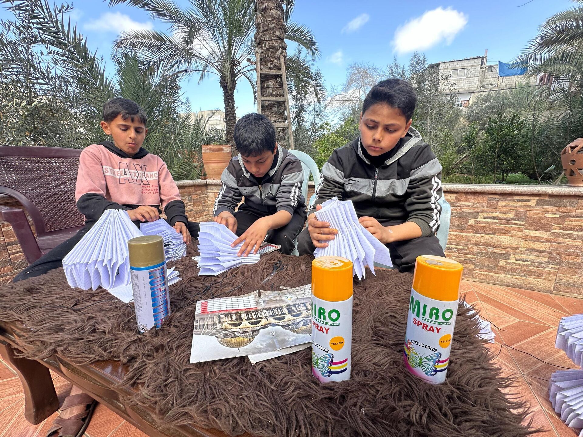 أطفال غزة يصنعون فوانيس رمضان من بقايا كتبهم المدرسية