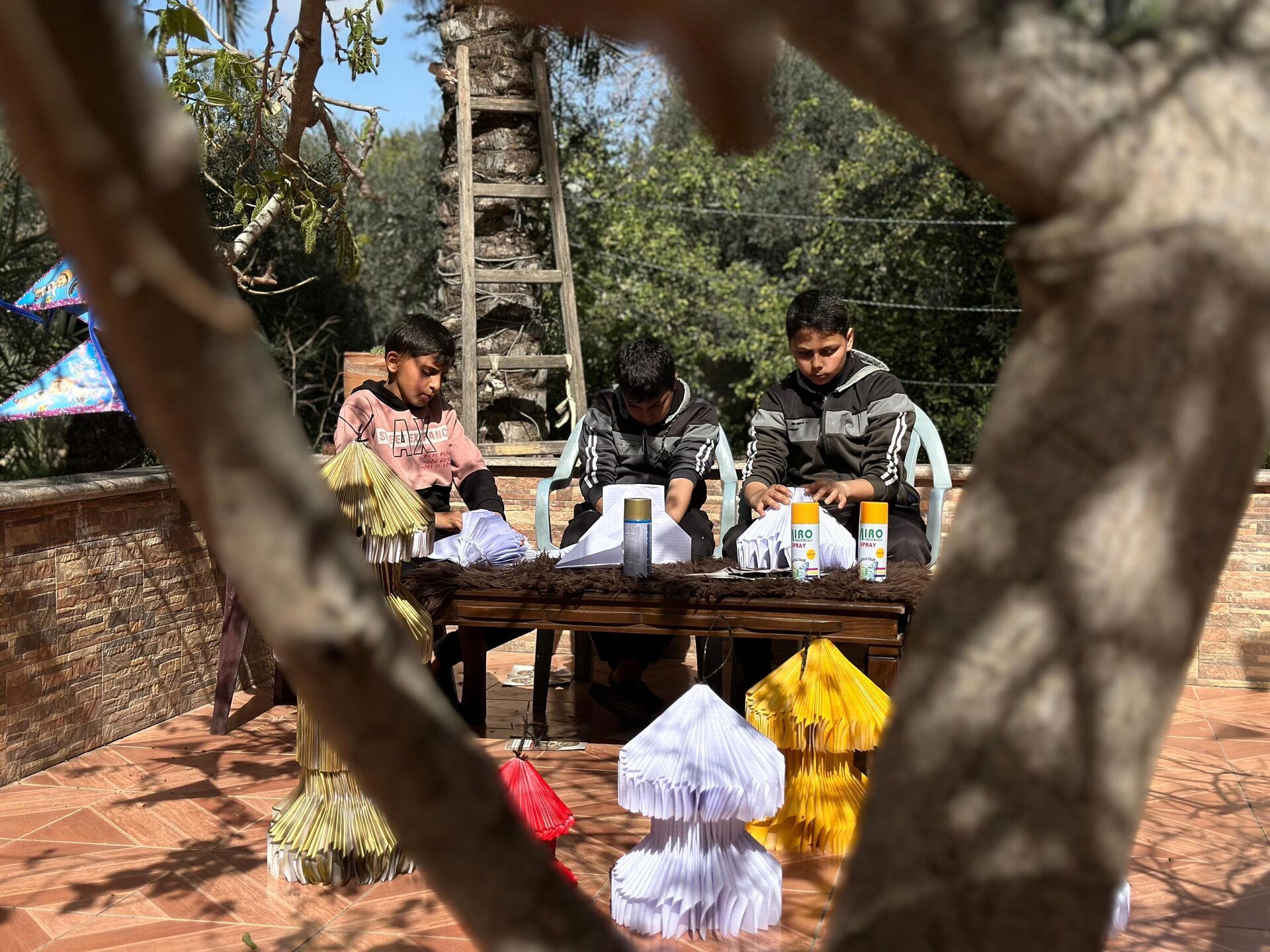 أطفال غزة يصنعون فوانيس رمضان من بقايا كتبهم المدرسية