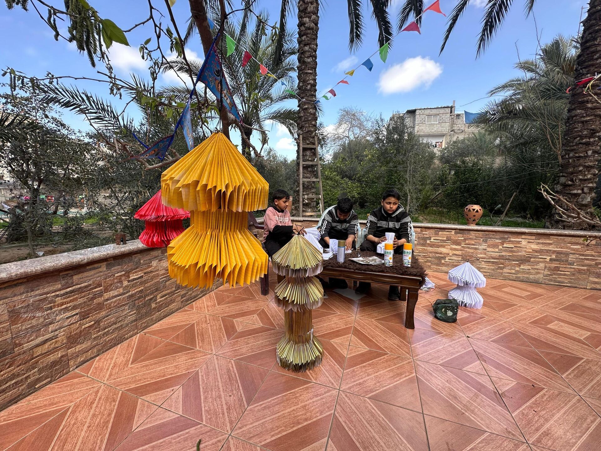 أطفال غزة يصنعون فوانيس رمضان من بقايا كتبهم المدرسية