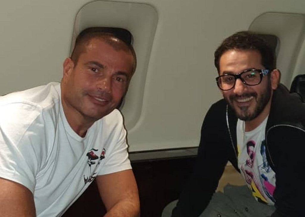 “الألوان جت كده صدفة”.. كواليس لقاء أحمد حلمي وعمرو دياب في الطائرة