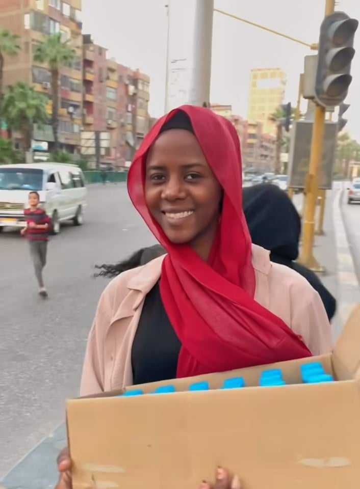 شاهد بالصورة والفيديو.. شباب سودانيون في مصر يعيدون ذكرياتهم الجميلة في الخرطوم ويوزعون مياه الشرب بــ(الكرتونة) على أصحاب السيارات وقت الإفطار في مدخل حي فيصل بالقاهرة