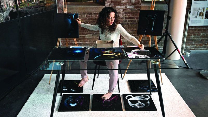 الامارات | هولندية ترسم بيديها وقدميها.. 10 لوحات في وقت واحد