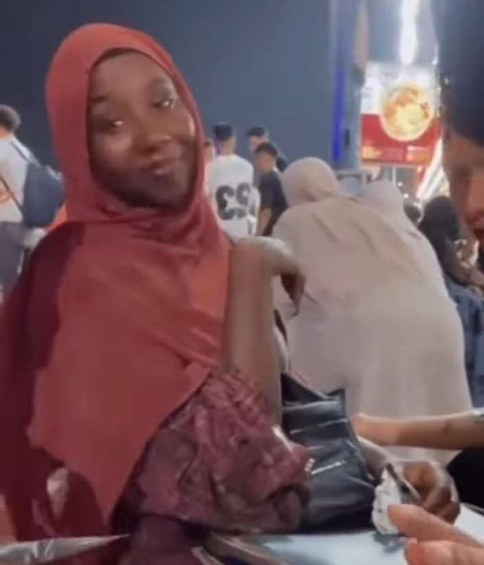 شاهد بالصورة والفيديو.. الغضب يجتاح مواقع التواصل الاجتماعي بالسودان بعد ظهور فتاة سودانية جالسة مع شاب مصري في الشارع العام وتغازله أمام الحاضرين: (بحبك يا حسن)