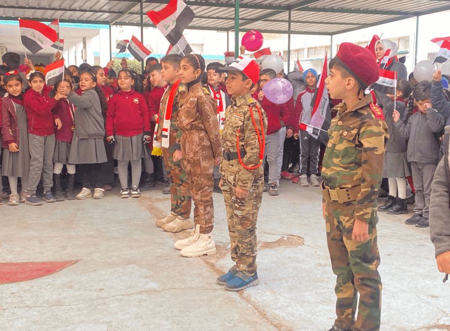 الزي العسكري والاعلام العراقية تغطي التلاميذ.. احتفالات المدارس بيوم النصر (صور)