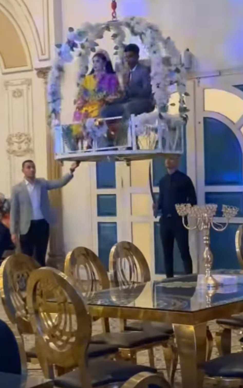 شاهد بالصورة والفيديو.. في تقليعة جديدة عريس سوداني وعروسته يدهشان المعازيم بدخولهما قاعة الفرح وهما معلقان في الهواء