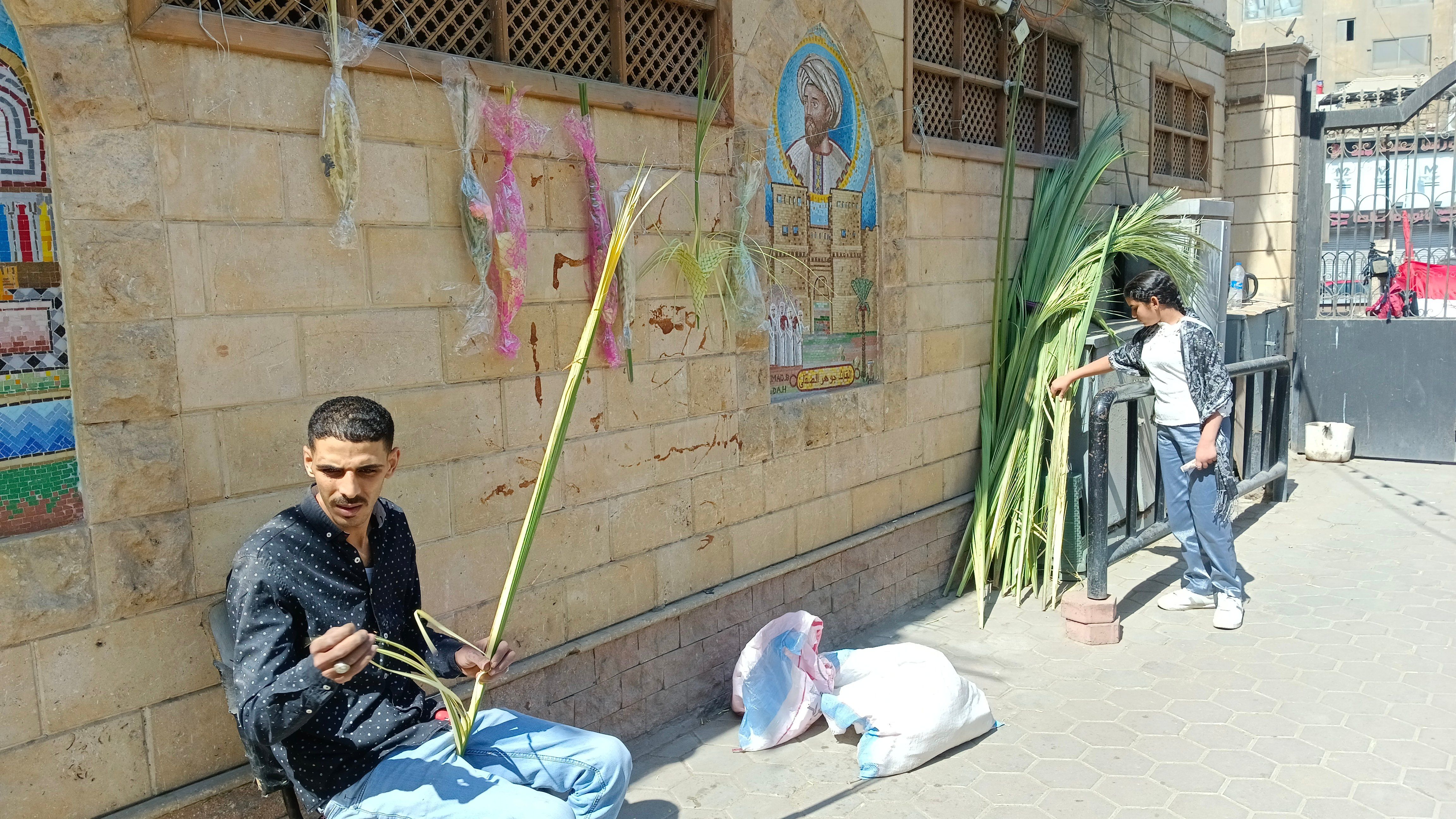 السعف يزين شوارع حارة زويلة احتفالاً بأحد الشعانين