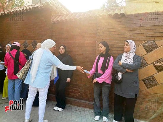 لتخفيف حرارة الجو.. أم توزع عصائر على طلاب الثانوية العامة فى الجيزة