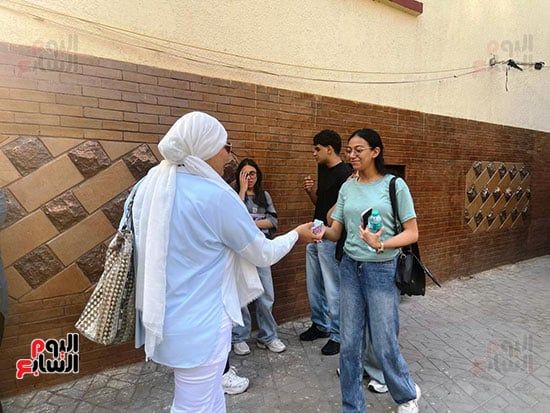 لتخفيف حرارة الجو.. أم توزع عصائر على طلاب الثانوية العامة فى الجيزة