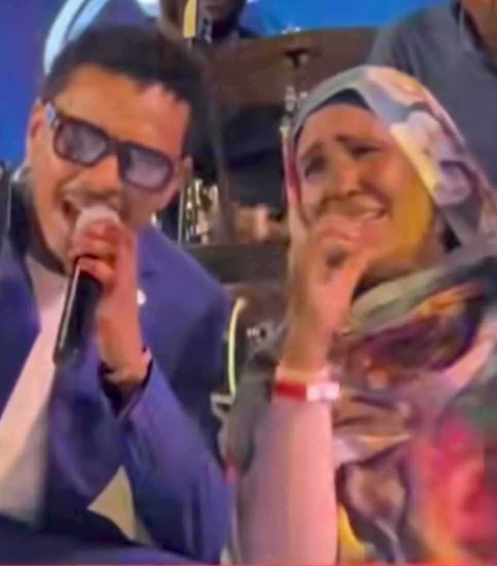 شاهد بالصورة والفيديو.. سيدة سودانية تقتحم حفل الفنان أحمد فتح الله بالقاهرة وتنهار بالبكاء والبندول يتعاطف ويتفاعل معها ويقبل يدها