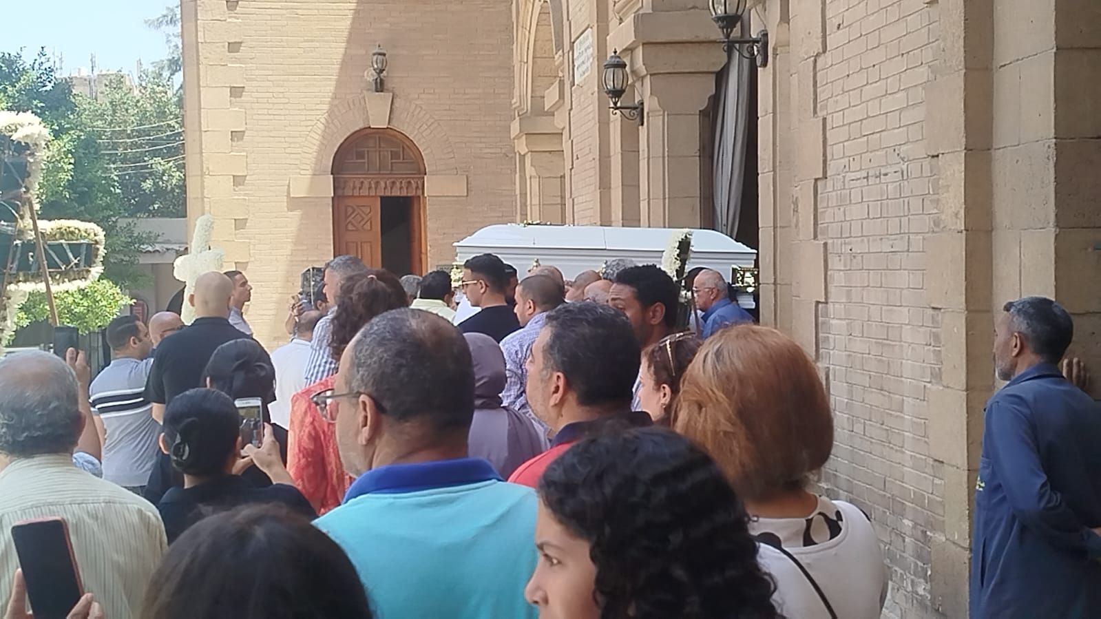 في تابوت أبيض.. نعش الفنان لطفي لبيب محمولا على الأعناق بكنيسة مارمرقس