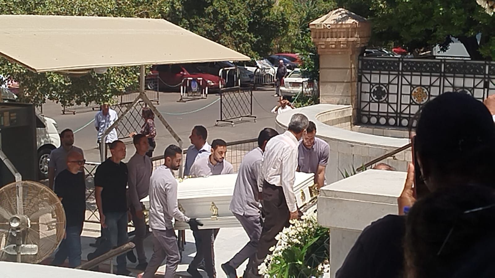 في تابوت أبيض.. نعش الفنان لطفي لبيب محمولا على الأعناق بكنيسة مارمرقس