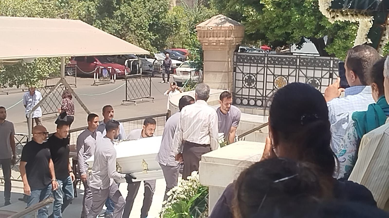 في تابوت أبيض.. نعش الفنان لطفي لبيب محمولا على الأعناق بكنيسة مارمرقس