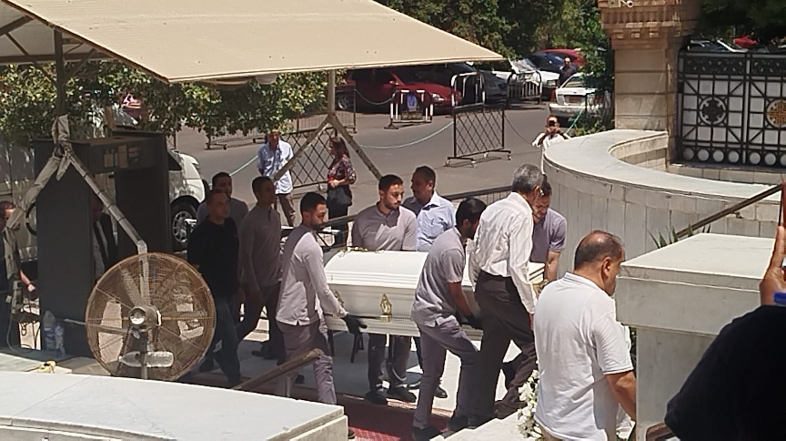 في تابوت أبيض.. نعش الفنان لطفي لبيب محمولا على الأعناق بكنيسة مارمرقس