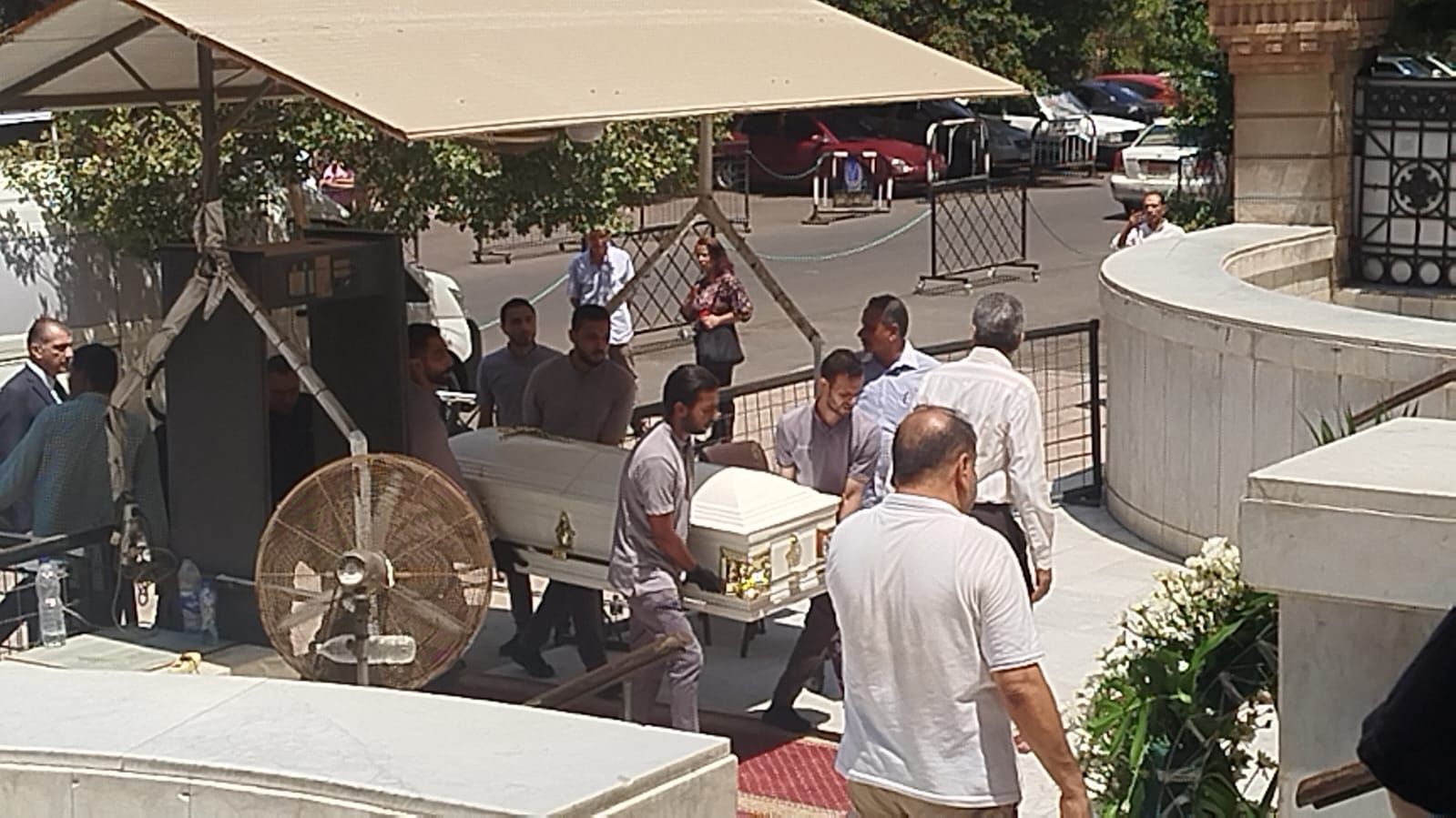 في تابوت أبيض.. نعش الفنان لطفي لبيب محمولا على الأعناق بكنيسة مارمرقس