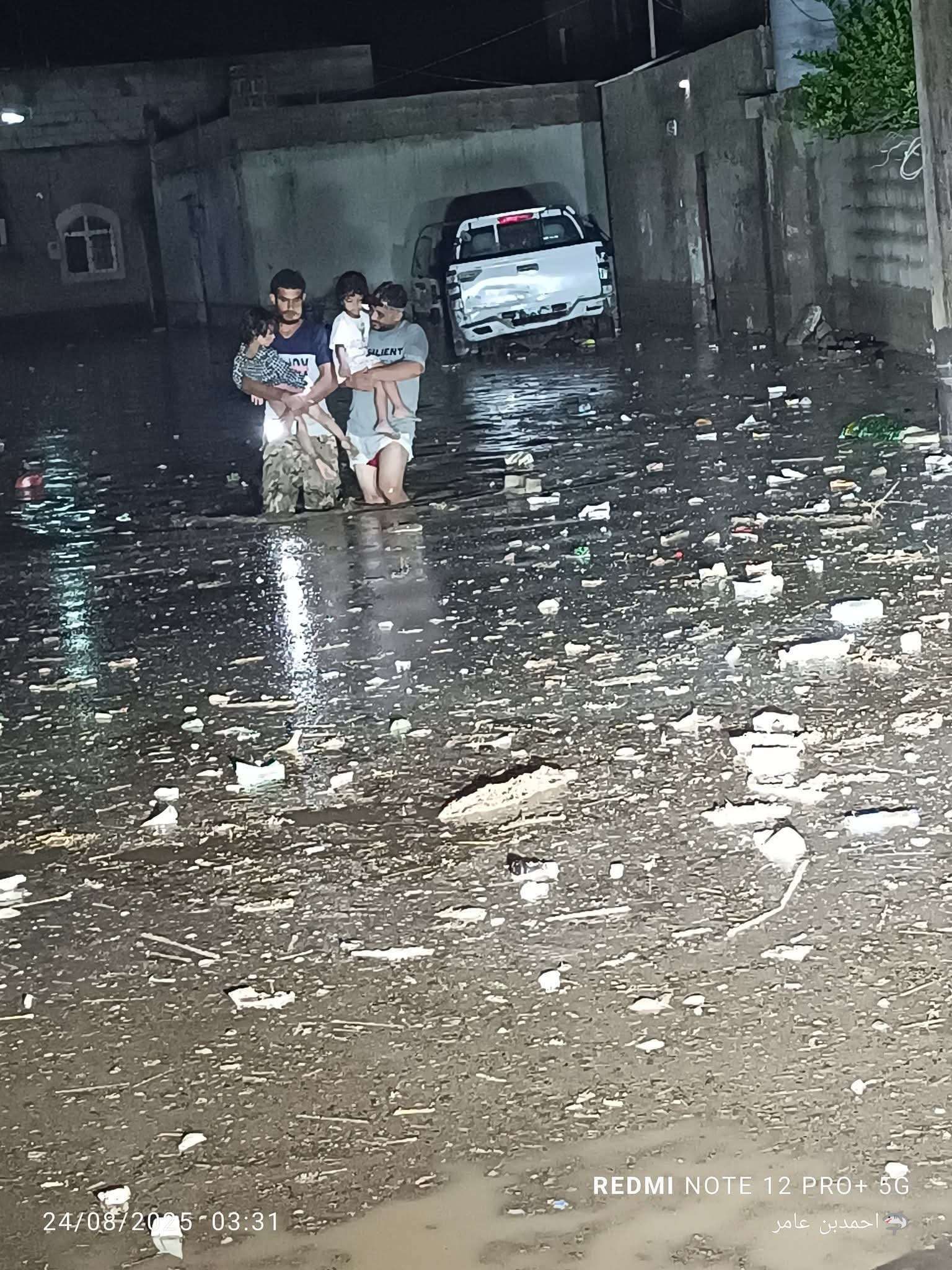 مشهد إنساني يهز القلوب: أبوان يحملان أطفالهما للخروج من منازل غمرها الماء بعدن