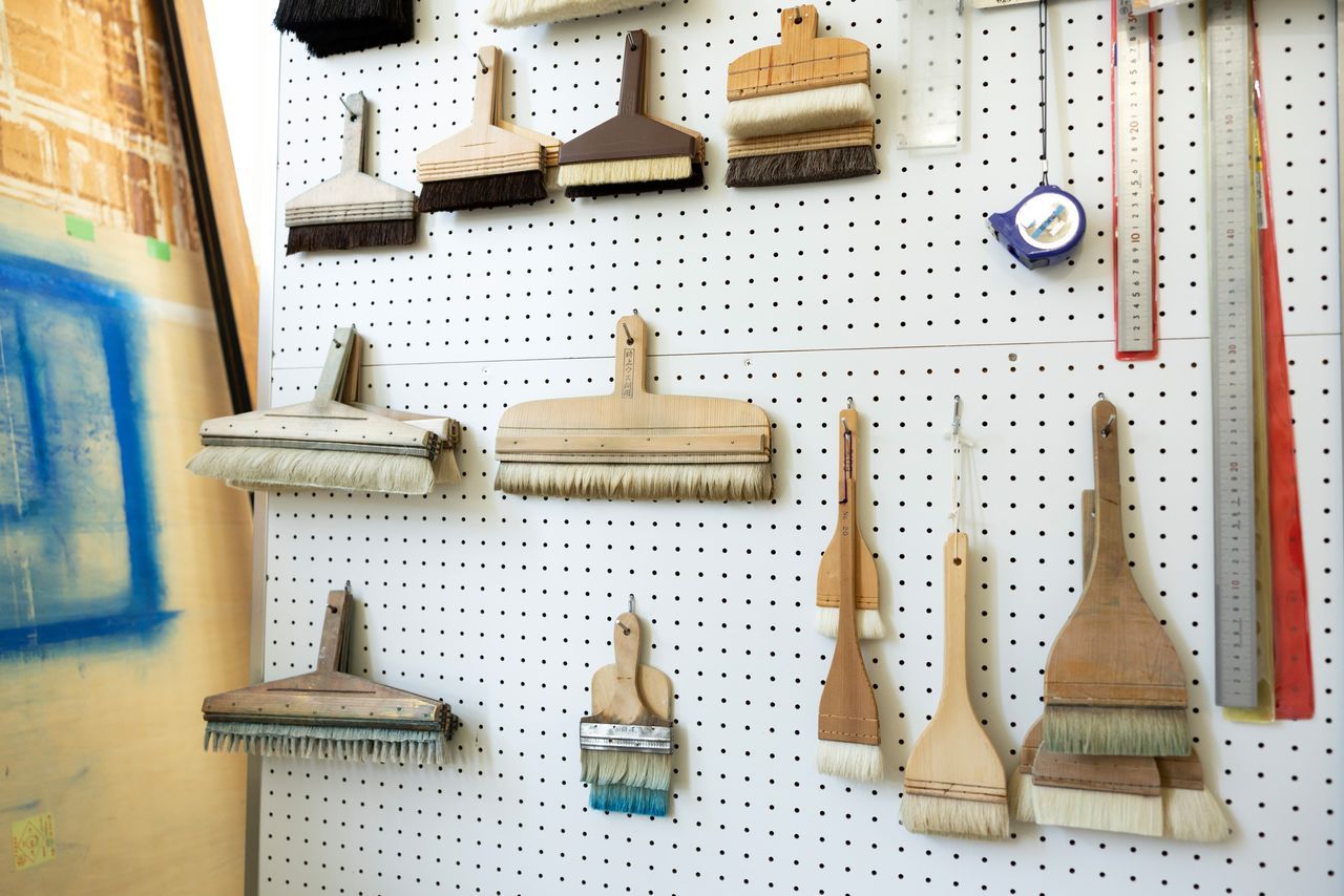 يحلم بأن يبتكر يومًا ما تصميمًا أصليًا مستوحى من الطبيعة. يقوم تاكاسوغي بتخصيص أدواته بنفسه. في أسفل الجهة اليسرى، يظهر فرشاة ذات شعيرات مخففة تُستخدم لرسم أنماط مخططة.(© كاواموتو سايّا)