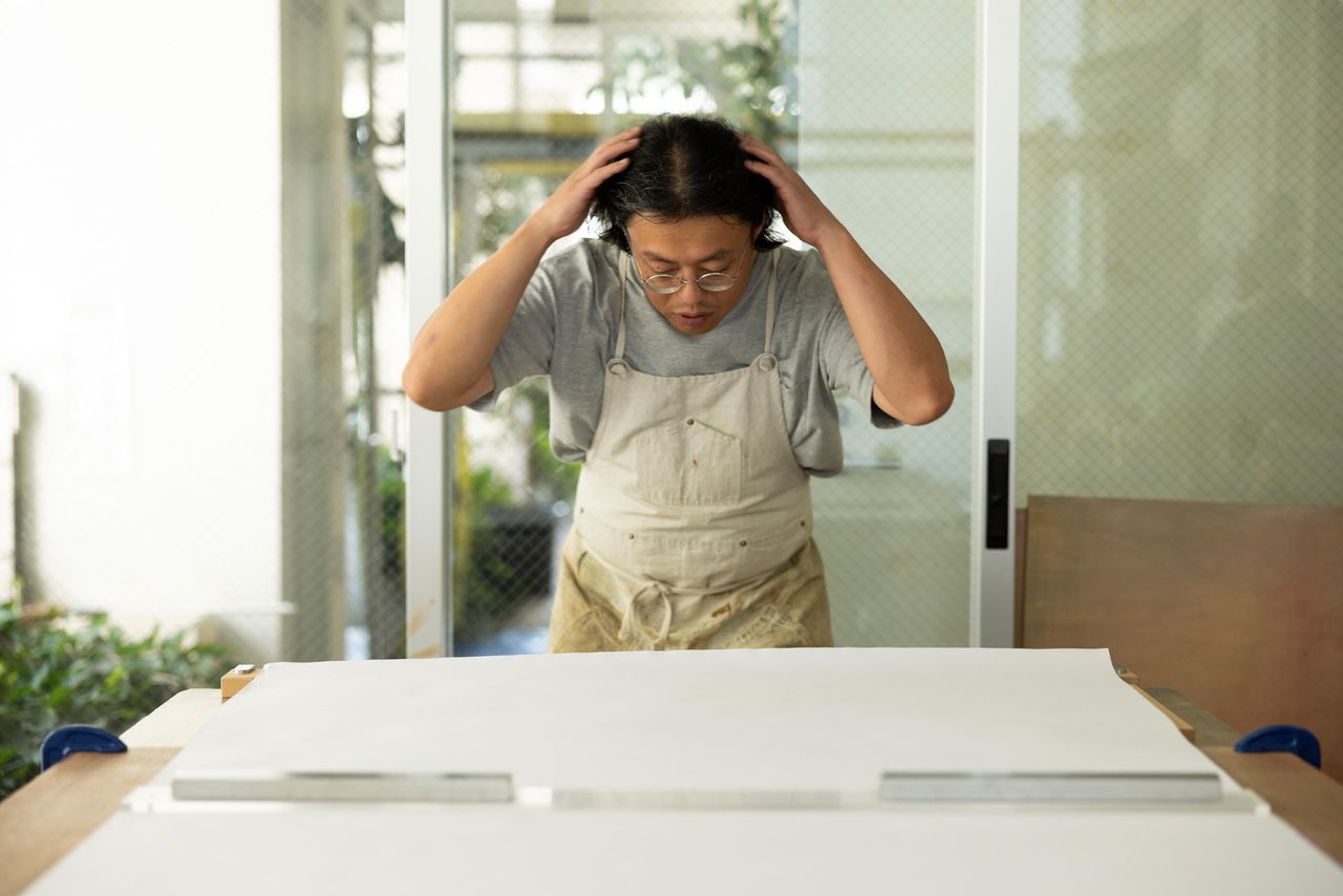 لمس الشعر قبل الطباعة هي تقنية تعلمها تاكاسوغي من حرفي مخضرم لتحسين انسيابية الحركة اليدوية.(© كاواموتو سايّا)