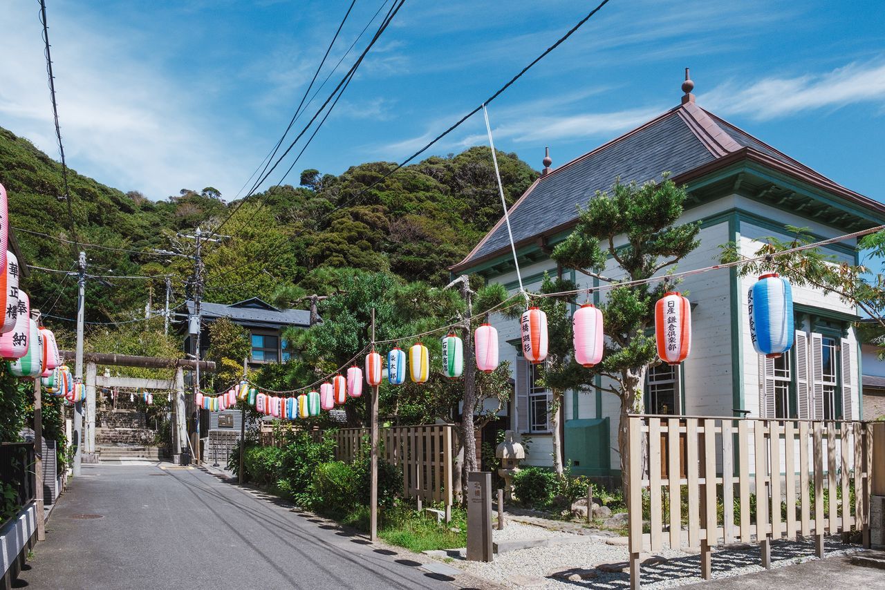 بوابة التوري في نهاية شارع مضاء بالفوانيس، والمبنى الغربي القديم على اليمين. (© كاواغوتشي يوكو)