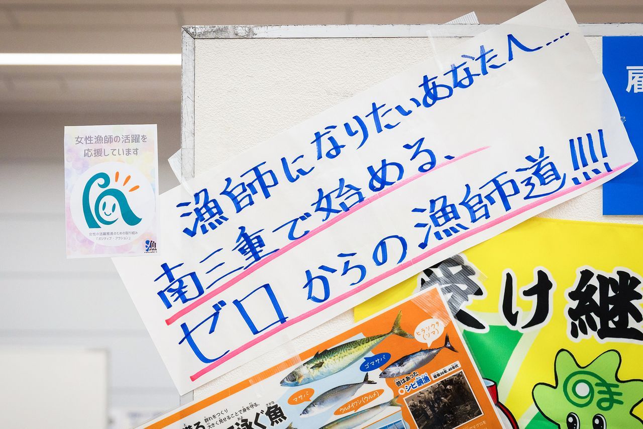 وضعت العديد من الأجنحة المشاركة في الفعالية ملصق (نحن ندعم الصيادين من النساء) الظاهر في أعلى الصورة على اليسار. (© Nippon.com)