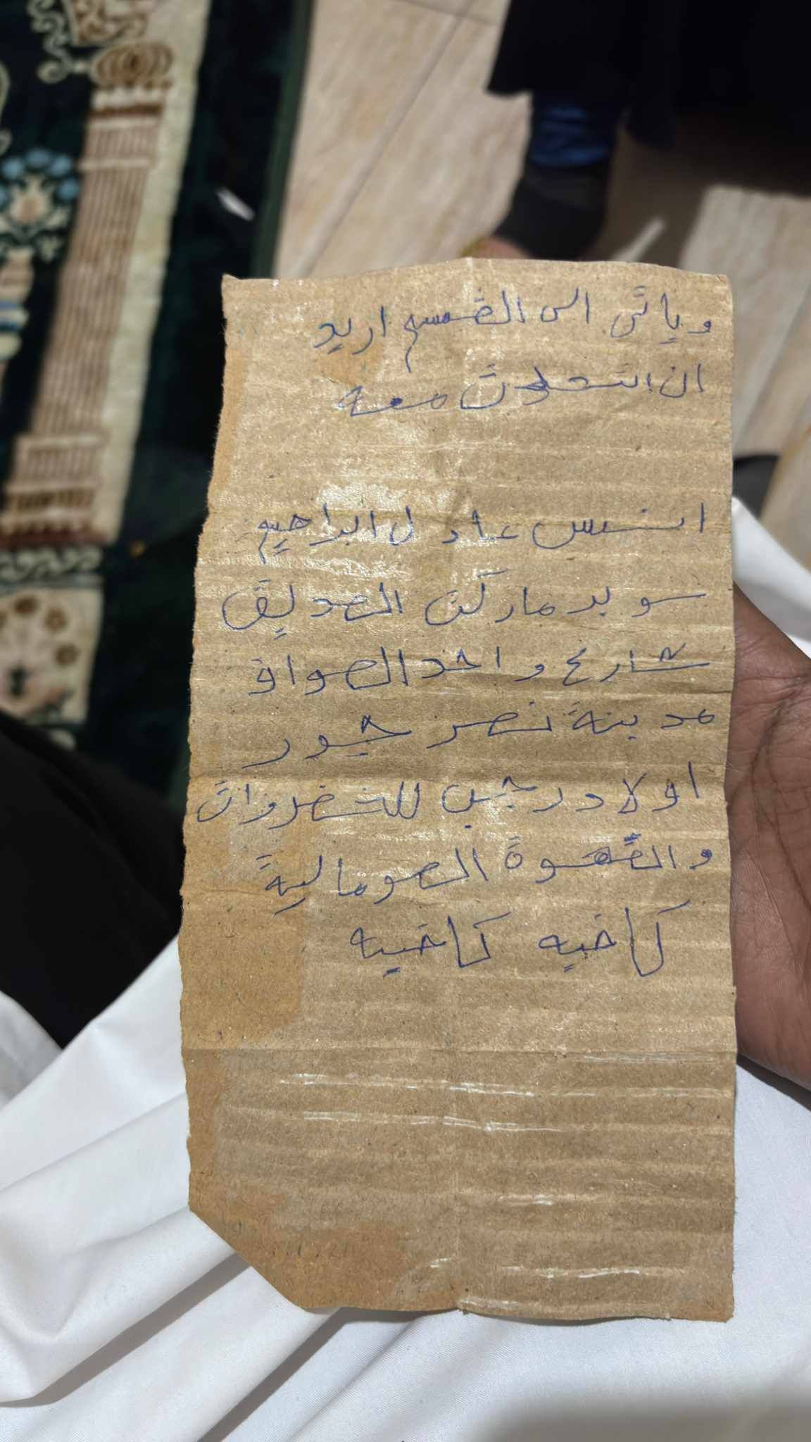شاهد بالصور.. مواطن سوداني محتجز بأحد إقسام الشرطة بمصر يرسل رسالة لأقاربه على قطعة “كرتون” (أحضروا لي ملابس)