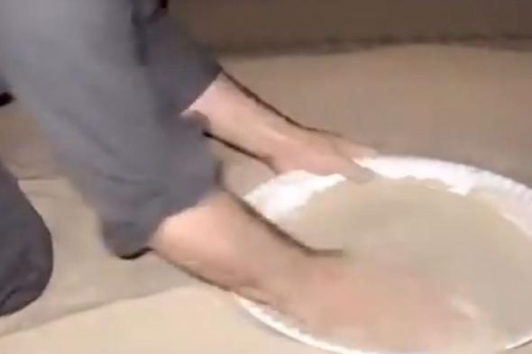 مشهد لشخص يثبت فيه أن ‏الرمل ينظف الصحن أفضل من الماء .. فيديو